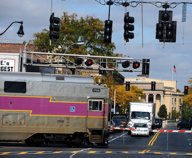 An MBTA commuter rail train makes its way through downtown Framingham.