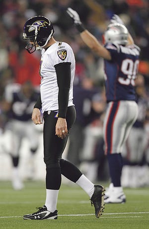 Baltimore Ravens kicker Billy Cundiff (7) walks off the field as New England Patriots outside linebacker Niko Koutouvides (90) celebrates after Cundiff missed a 32 yard field goal in the closing seconds of the AFC Championship NFL football game Sunday, Jan. 22, 2012, in Foxborough, Mass. The Patriots defeated the Ravens 23-20 to win the AFC Championship. (AP Photo/Winslow Townson)