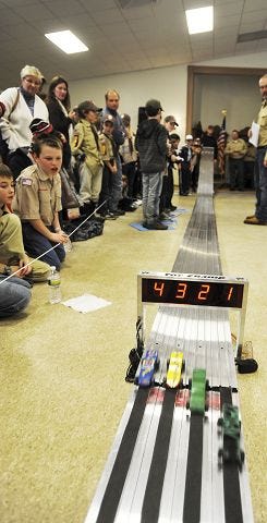 Monika O'Clair/Democrat photo
Dover Cub Scout Pack 173 members watch cars race down the track during a Pinewood Derby at the Dover Elks Lodge Sunday.