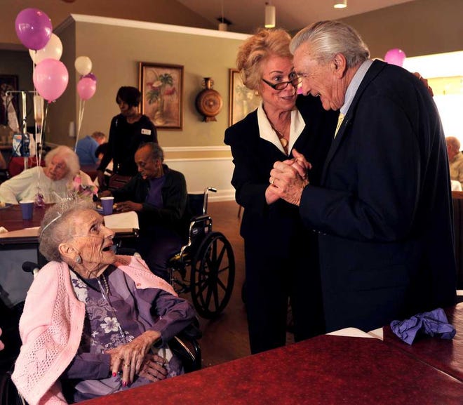 Anne Kemp (left) watches as son Jim Kemp dances with his wife, Jane, to a song by Louis Armstrong. Anne Kemp celebrated her 103rd birthday with a party Tuesday at her nursing home.