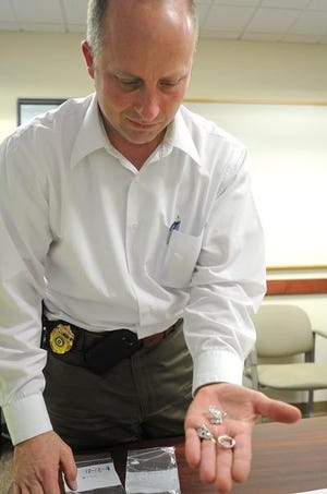Bridgewater Detective Chris Shaw holds several pieces of recovered stolen jewelry.