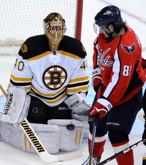 Bruins goalie Tuukka Rask (40) stops a shot as Washington's Matthieu Perreault watches during the first period of the Capitals' 5-3 win.