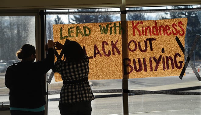 Marlborough eighth graders Michelle Santiago, left, and Latequita Tutt put up a mural as part of the school's participation in the anti-bullying "No Name Calling Day" Wednesday.