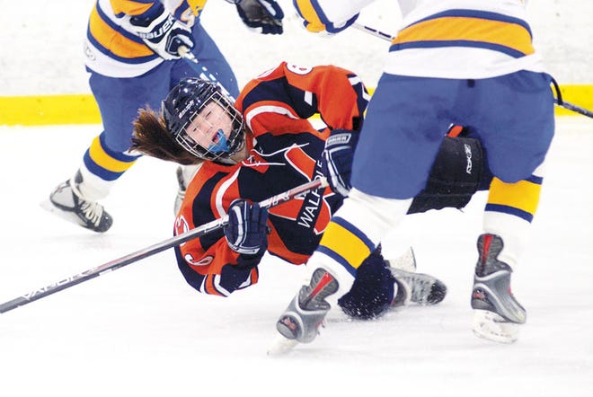 Walpole’s Rachael Barry is sent to the ice during the Rebels’ 6-1 win over Norwood Friday night.