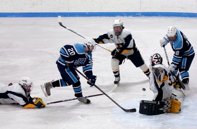 Hanover defenders converge on Scituates Dan DelGrosso #20 who tries to pass the puck to Josh Beck #18.