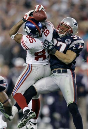 AP Photo/Gene Puskar - In this Feb. 3, 2008 file photo the New York Giants receiver David Tyree (85) catches a 32-yard pass in the clutches of New England Patriots safety Rodney Harrison (37) during the fourth quarter of the Super Bowl XLII football game.