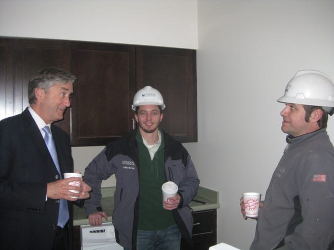 Congressman John Tierney speaks with Windover’s Tadhg Morgan and Andrew Sullivan, project leaders of the Holcroft Park Homes project being built on Mill Street in Beverly.