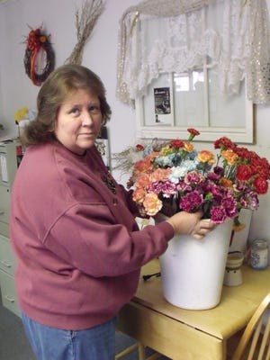 Getting ready for the big event
Cheryl Acuff of CJ Flowers and More looks over a shipment of carnations in preparation for "An Evening for Memories." CJ Flowers and More is giving a carnation to every lady that attends the fundraising dinner on Feb. 14. CJ Flowers and More is also donating two flower displays to be used as decorations for the dinner. These displays will be given as door prizes to one lucky person from the 5 p.m. and 7 p.m. seating.