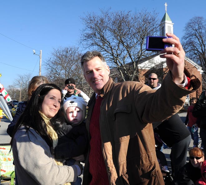 U.S. Sen. Scott Brown photographs himself with Amanda Genest of Whitman, and her daughter Braelan, 17-months, during the 28th annual East Bridgewater Christmas Parade.