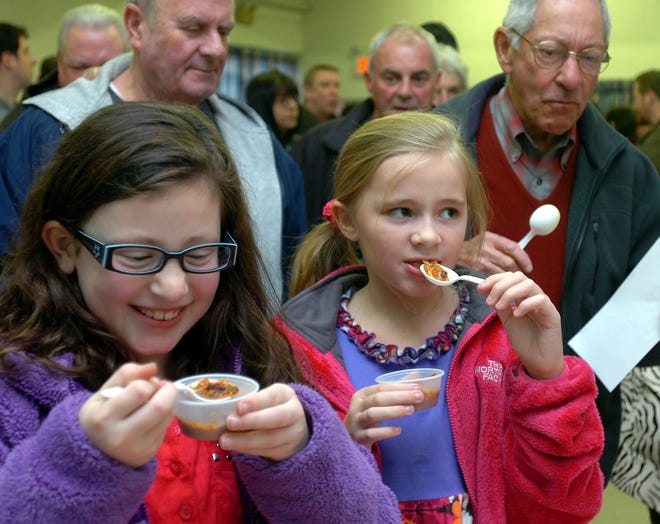 Natalie MacDonald, 8, left, and Emma Giovanetti, 9, both of Weymouth, sample varieties of chili at the chili cook-off at the Houghs Neck Congregational Church in Quincy on Saturday, Jan. 28, 2012.