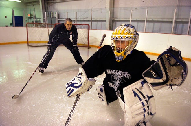 Brian Daccord, left, gives a lesson to Camden Ludwig, 12, on Jan. 9 at the Hat Trick Training Center in Middleton. Ludwig, of Groveland, is on the Valley Jr. Warriors.