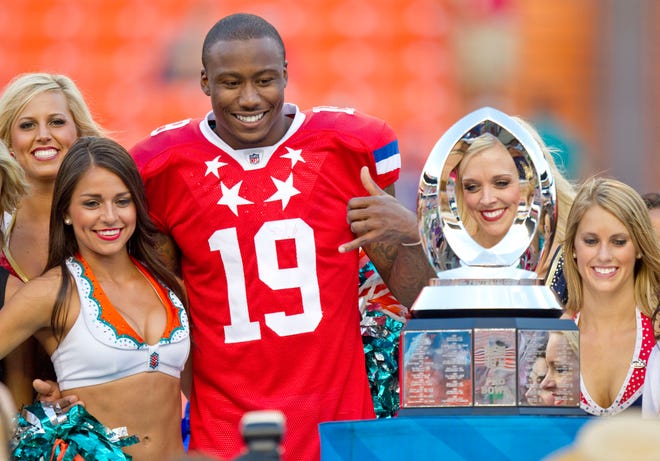 Miami Dolphins wide receiver Brandon Marshall (19) of the AFC, surrounded by the NFL Cheerleaders, poses for pictures after being named the Pro Bowl football game's Most Valuable Player Sunday, Jan. 29, 2012, in Honolulu. The AFC defeated the NFC 59-41.