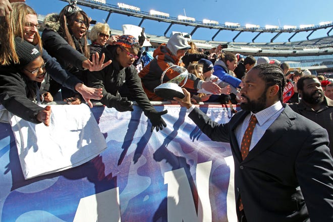 Patriots linebacker Jerod Mayo, front right, displays the Lamar Hunt Trophy to fans as he exits the stadium following Sunday's Super Bowl send-off rally in Foxboro.
