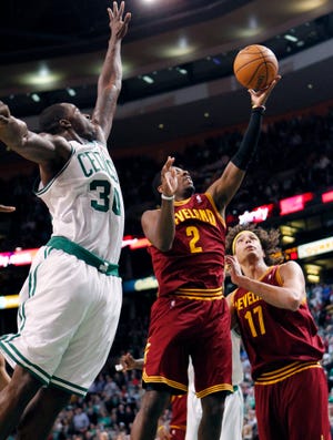 Cavaliers' Kyrie Irving (2) shoots the go-ahead basket between the Celtics' Brandon Bass (30) and Cavaliers' Anderson Varejao (17) with seconds left in Sunday's game in Boston. The Cavaliers won 88-87.