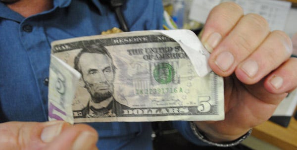 Milford Police Chief Gary Williams holds the fake $5 that circulated in Milford last week.