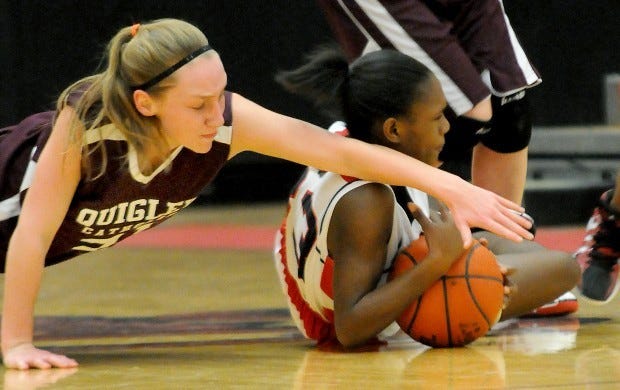 Quigley's Drew Meeker tries to steal the basketball from
Aliquippa's Deshawnda West during the game.