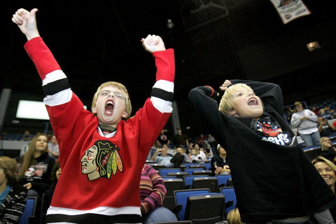 Austin Nyren, 11, (left) and Gaven House, 8, cheer after an IceHogs goal during an exhibition game Tuesday, September 28, 2010, against the Peoria Rivermen at the MetroCentre.