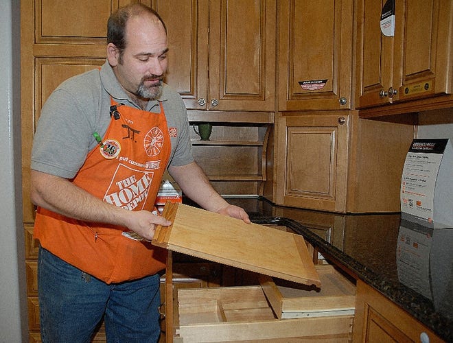 J. T. Eastwood, Kitchen Department Manager of Home Depot in Stroud Township, demonstrates how cabinetry has become more space efficient. Inside one drawer are various compartments for cutlery and even a removable cutting board.