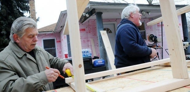 Volunteers from Home Depot in Chippewa and members of Vietnam
Veterans of America make improvements to Keith Beitty's home in
White Township. Beitty was injured in the Iraq war and now suffers
from nerve damage in his leg and back. Here, Pete Castronovo and
Ted Cvetic, both of the Home Depot, build a laundry room table.