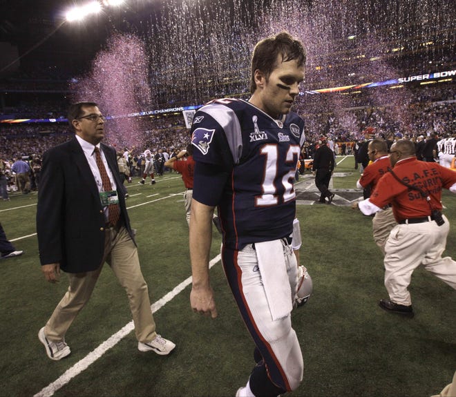Patriots quarterback Tom Brady walks off the field after the Pats' 21-17 loss to the New York Giantson Sunday.