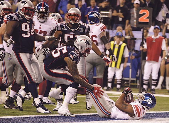 New York Giants running back Ahmad Bradshaw, bottom right, scores a touchdown against New England Patriots linebacker Brandon Spikes during the second half of the NFL Super Bowl XLVI football game, Sunday, Feb. 5, 2012, in Indianapolis. (AP Photo/Matt Slocum)