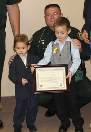 Joseph Hutcheson, Flagler County deputy Steve Williams and Christopher Kelly at a ceremony honoring Joseph