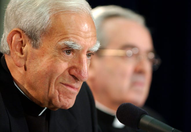 In this July 15, 2003 file photo, Cardinal Anthony J. Bevilacqua listens to a reporter's question as St. Louis Archbishop Justin F. Rigali, right, listens at a news conference in Philadelphia. The child-molestation scandal in the Archdiocese of Philadelphia has taken a mysterious new turn, with prosecutors asking a coroner to examine the body of Cardinal Anthony Bevilacqua to establish whether he died of natural causes, Friday, Feb. 10, 2012. (AP Photo/Jacqueline Larma, File)