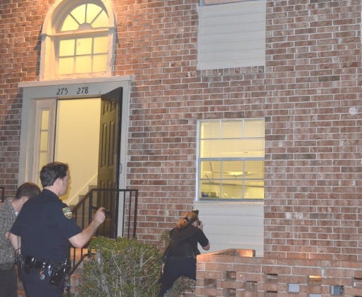 Jacksonville police look at bullet holes in windows and a wall at one part of the Plantation apartment complex at 7061 Old Kings Road S. after a Friday night drive-by shooting. No one was hurt.
