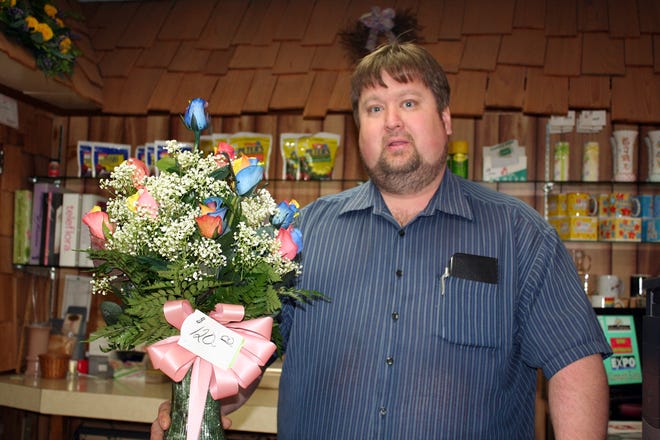 Sid’s Flower Shop owner Kevin Kasper displays a bouquet of “rainbow roses,” which is the hot new trend in flowers for Valentine’s day. The roses, imported from Ecuador, have colors including blue, pink, yellow, orange, red and purple in one flower.