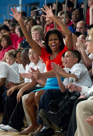 First lady Michelle Obama cheers Friday with students from Nancy Moseley Elementary School during a Let's Move event with members of Bravo's series "Top Chef" at Kleberg Rylie Recreation Center in Dallas, during her three-day national tour celebrating the second anniversary of Let's Move.