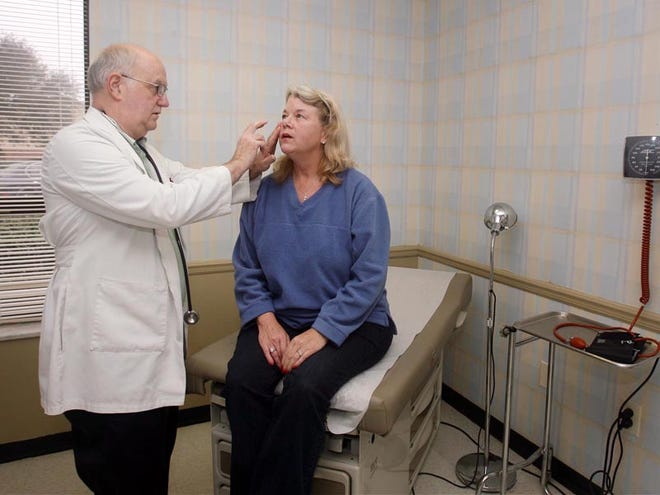 Dr. George Luckey checks Virginia Steagall, a patient who said she has a sinus and upper respiratory infection, at the Maude L. Whatley Health Center in Tuscaloosa on Friday.