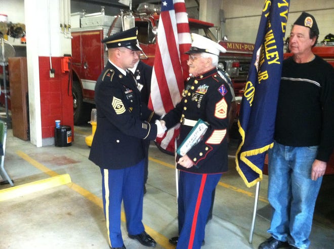 Army First Sgt. Gene Paul Harding, left, gives a certificate of appreciation to his great uncle, retired Marine Corps gunnery Sgt. Tom Mazzarella, during a ceremony at the Williamsville Fire Engine Co. headquarters in the Rogers section of Killingly on Sunday. Pictured to the right of Mazzarella is Harding?s father, Gene Barriere, who was given a flag flown in a bomber aircraft and a certificate by his son.