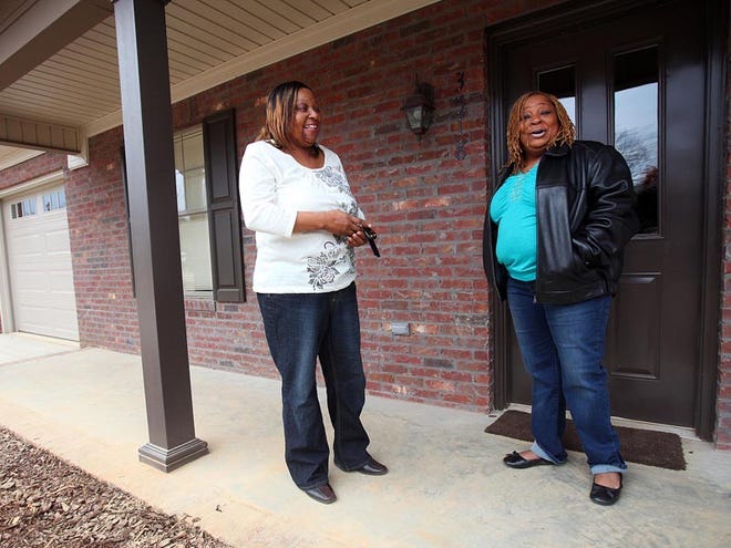 Demetrius Washington, left, and Tina Taylor talk about their new homes at Bernice Hudson Washington Estates in Tuscaloosa on Friday. The Tuscaloosa Housing Authority used federal HOME funds to build nine houses that will be sold to first-time homebuyers and people who are long-term renters.