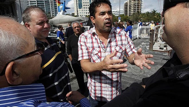 Miami Marlins manager Ozzie Guillen (second from right) gestures as he chats with members of the media, Monday, Feb. 13, 2012, in Miami.