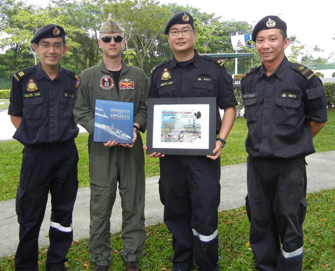 Lt. Cmdr. Trey Walden, of the VP-16 "War Eagles," exchanges gifts with submariners from the Republic of Singapore Navy on Feb. 2. Personnel from the Singaporean Navy accompanied a VP-16 crew during an anti-submarine training flight. VP-16 is currently deployed to Kadena Air Base in Okinawa, Japan.