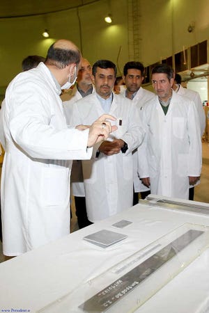 Iranian President Mahmoud Ahmadinejad, center, is escorted Wednesday by technicians during a tour of Tehran's research reactor center in northern Tehran, Iran.