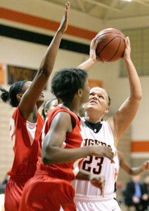Massillon's Nicolette Briceland shooting with Akron East's London Dancy and Airelle Sibley blocking.