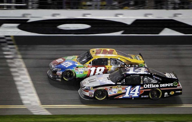Kyle Busch (18) beats Tony Stewart to the finish line with a last-second pass to win the NASCAR Budweiser Shootout on Saturday night at Daytona.
