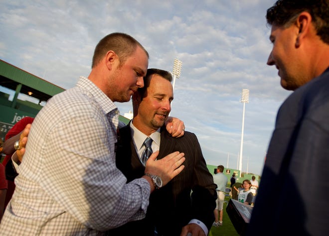 Boston Red Sox pitcher Tim Wakefield, center, is embraced by teammate Jon Lester, left, as Sox minor league pitching coach Rich Sauveur looks on after Wakefield announced his retirement at the Sox's baseball spring training complex Friday, Feb. 17, 2012, in Fort Myers, Fla.