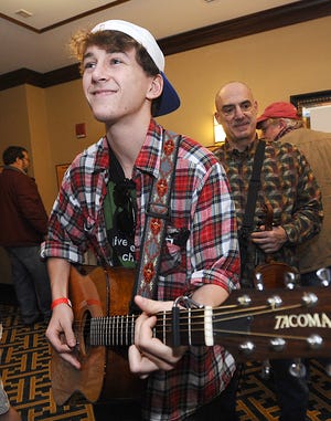 Zach Sarapas, 18, of Franklin, joins a group of bluegrass musicians jamming outside a Sheraton Framingham conference room during the 27th Annual Joe Val Bluegrass Festival Saturday.