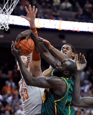 Baylor forward Quincy Acy, right front, fights for a rebound with teammate Perry Jones III, rear, and Texas center Clint Chapman, left, during their game Monday in Austin. Baylor won, 77-72.