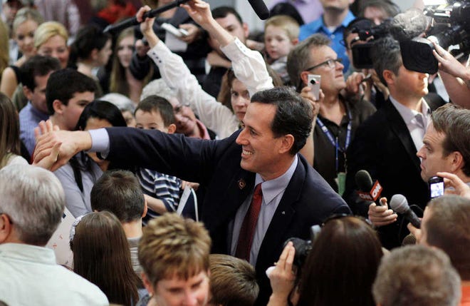 Republican presidential candidate former Pennsylvania Sen. Rick Santorum shakes hands with supporters Tuesday during a campaign rally at the El-Zaribah Shrine Auditorium in Phoenix, Ariz.