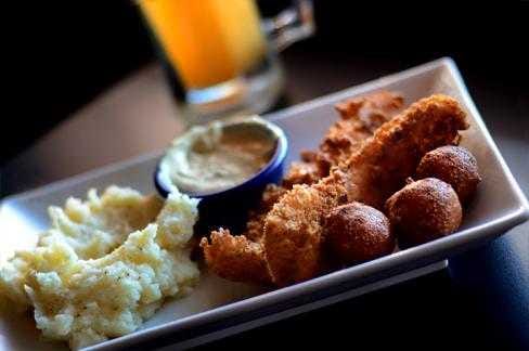 Henry T's Bar and Grill's Basa fish - two hand breaded fish fillets and hush puppies with a side of mashed potatoes and a frosty mug of beer.