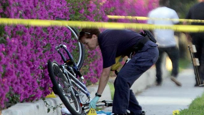 Investigators work the scene in West Palm Beach where a 13-year-old boy on a bicycle was shot multiple times Wednesday afternoon.