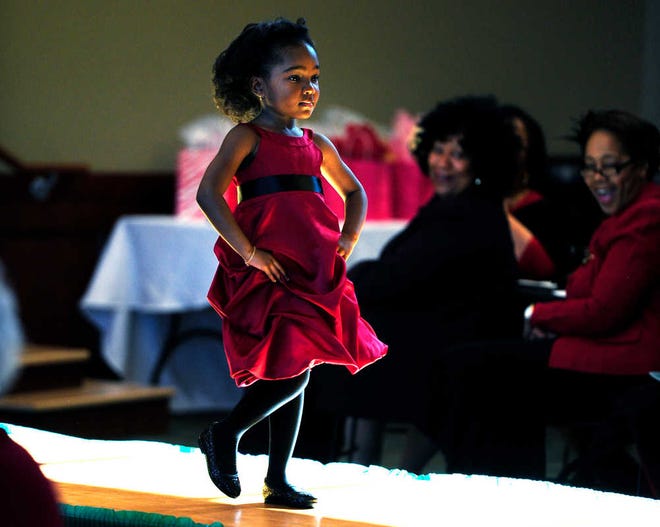 Tayana Wells, 4, models a red dress during the Go Red for Women Fashion Show and Heart Disease Symposium at the Kroc Center on Sunday afternoon.
