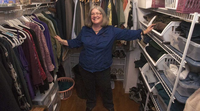 Susan C. Pinsky of Acton, a professional organizer and author, stands in a bedroom closet she shares with her husband. On the left are her clothes, on the right, his. She explained the difference between her side and his as “attractive and inefficient” and “less attractive and more efficient.”