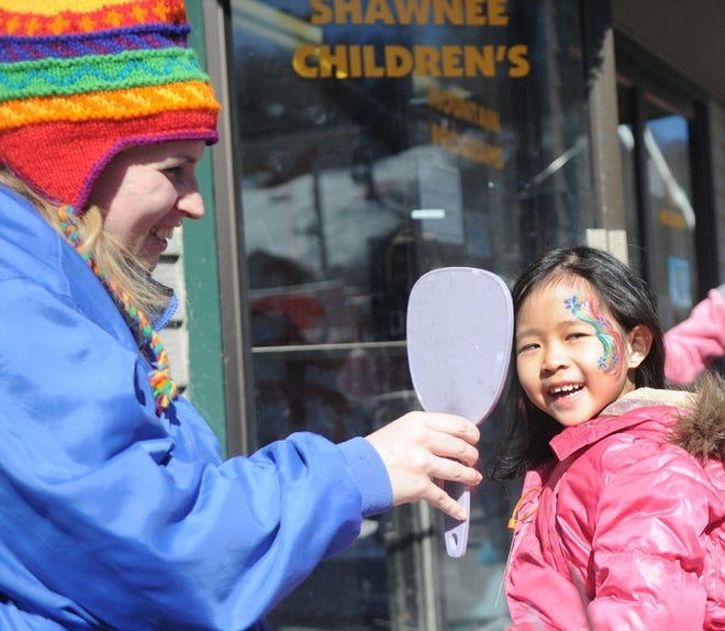Georgette Clark of Aardvark Entertainment shows Kriselle Changtongkan, of New York, her face painting during the annual Shawnee Mountain Winter Carnival held on Sunday. It was the first time in the Poconos for Kriselle and her family.