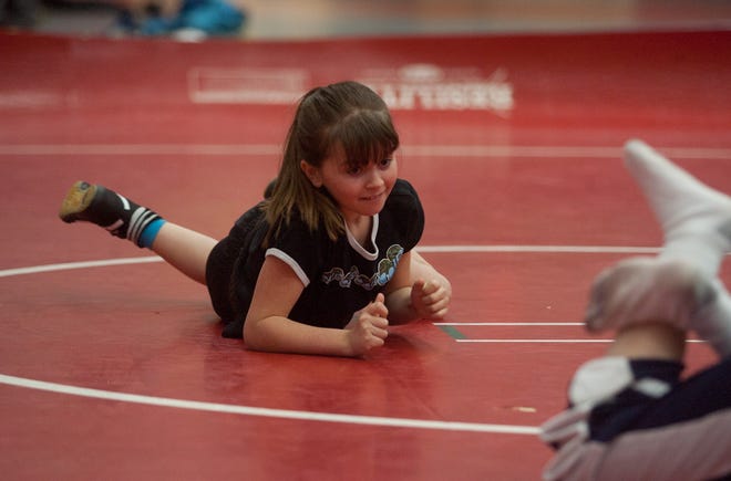 Maggie Mallett does an "army crawl" drill during wrestling practice in Milton. Maggie, a student at the Pierce Middle School in Milton, is the only girl wrestler on a team of 20.