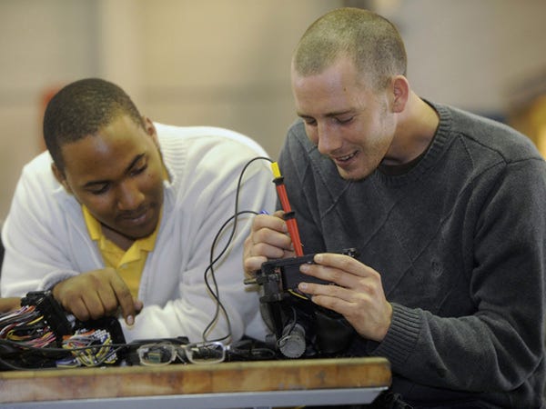Cape Fear Community College students Ryan Compton (left) and Micah Batchelor (right) trace the grounding wires of a Caterpillar 1902 Horse Power C32 Acert diesel engine, which was donated to the school's Marine Diesel Workforce program, during class on Wednesday.