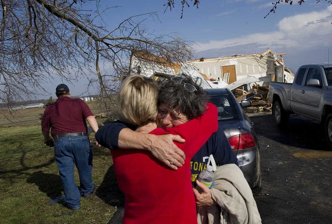 Sandra Redman consoles neighbor Vicki Simpson after riding out a tornado in her basement in Wadesville, Ind. Simpson's dogs stayed in the garage because she didn't have time to let them in. The garage was demolished, but the dogs were fine.
